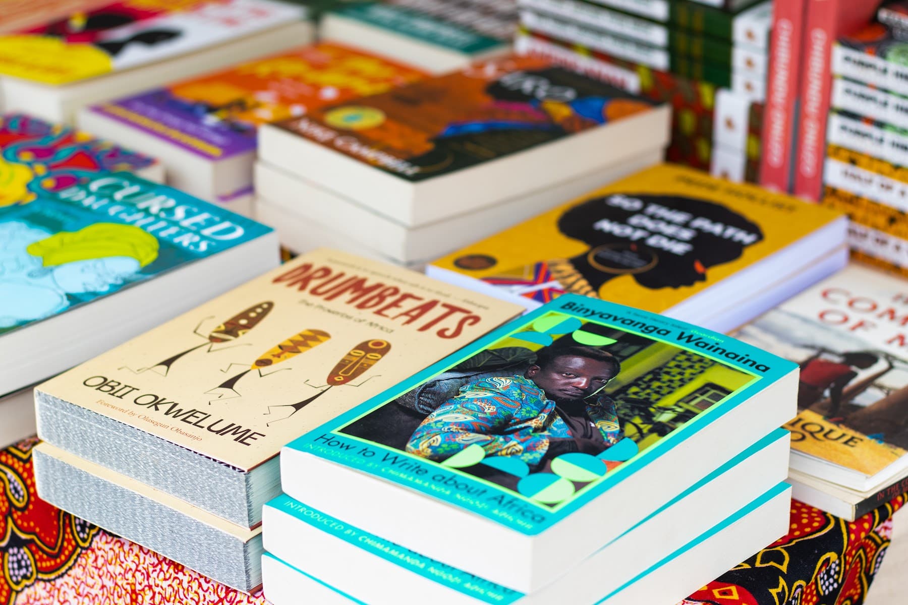 Stacks of books at the festival book stall, including a Binyavanga Wainaina title