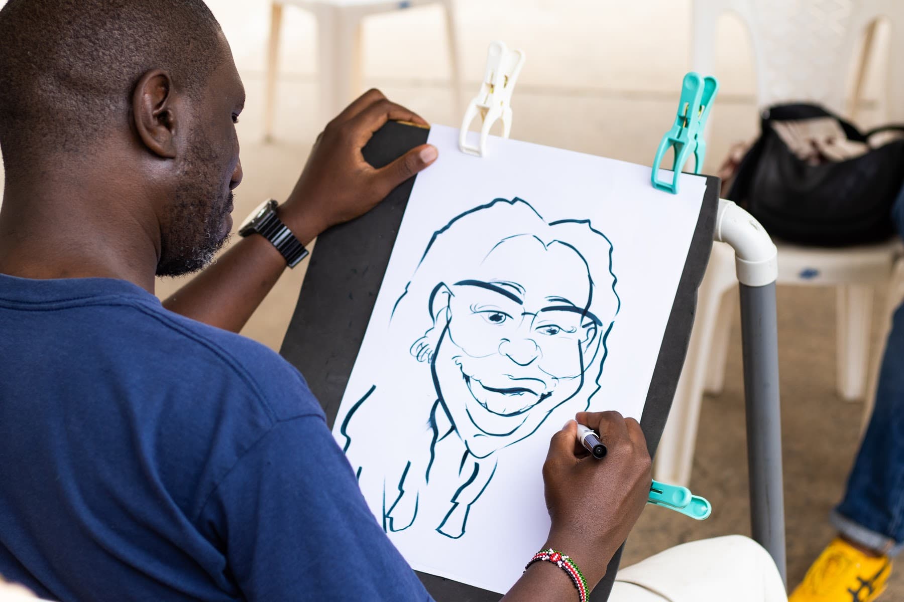 A caricature artist drawing a portrait in marker